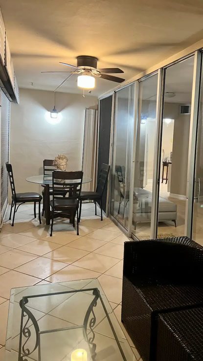 Private screened balcony with dining table and seating overlooking the course